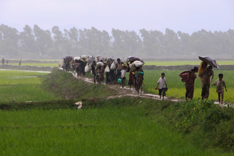 Rohingya refugees from Rakhine state in Myanmar walk along a path near Teknaf in Bangladesh on September 2, 2017.
Around 400 people — most of them Rohingya Muslims — have died in violence searing through Myanmar’s Rakhine state, the army chief’s office said on September 1, with tens of thousands forced to flee across the border into Bangladesh. A further 20,000 Rohingya have massed along the Bangladeshi frontier, barred from entering the South Asian country, while scores of desperate people have drowned attempting to cross the Naf, a border river, in makeshift boats.
 / AFP PHOTO / Suzauddin RUBEL