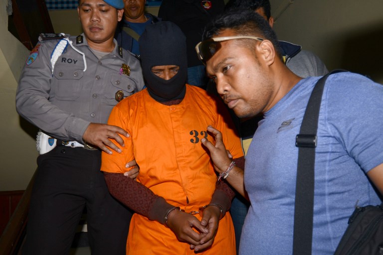 I Putu Astawa (C), a suspect in the murder of an elderly Japanese couple in the Indonesian resort island of Bali, is escorted to a press conference at the Denpasar police station on Bali island on September 18, 2017. Photo: Sonny Tumbelaka/AFP