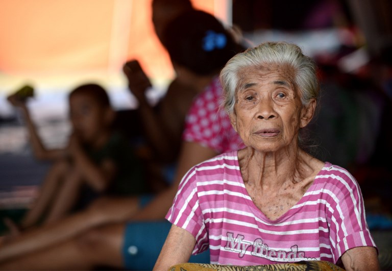 An elderly woman waits inside an evacuation center in Klungkung regency, Bali on September 25, 2017. Photo: Sonny Tumbelaka/AFP