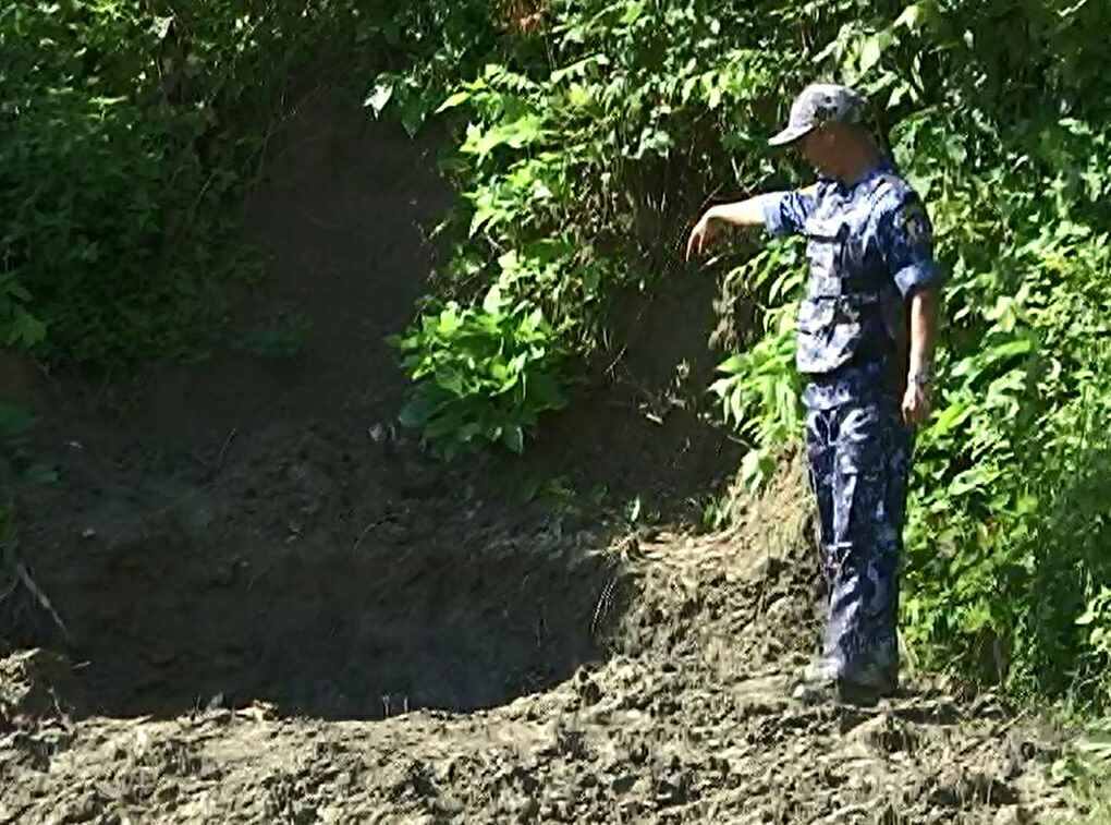 A Myanmar soldier stands beside a mass grave unearthed on September 24, 2017. Photo: Facebook / Office of the Commander-in-Chief