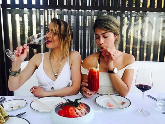 Amber Heard and friend, Raquel Pennington, indulge in some sashimi. Photo via Instagram @amberheard