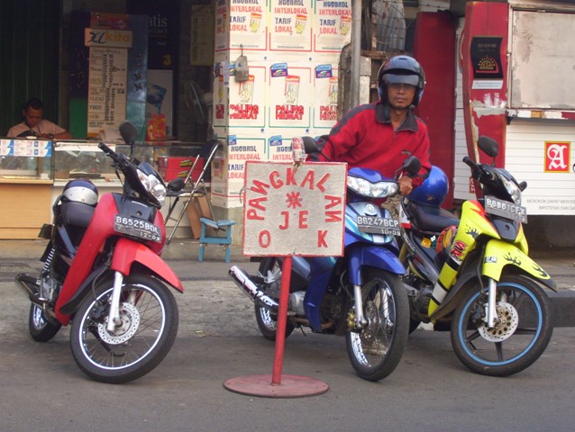 An unofficial pangkalan ojek (motorcycle taxi base). Ojek drivers may have to pick up and drop off passengers and government mandated spots in the future. Photo: Wikimedia Commons
