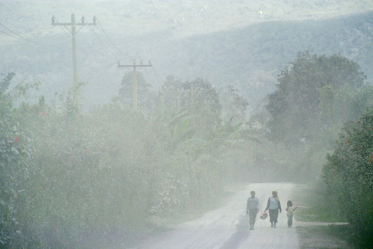 Villagers walk along an ash-covered road in Naman Teran village in Karo, North Sumatra on August 3, 2017, after the Mount Sinabung volcano erupted. Sinabung roared back to life in 2010 for the first time in 400 years. After another period of inactivity it erupted once more in 2013, and has remained highly active since. Photo: Tibta Pangin/AFP