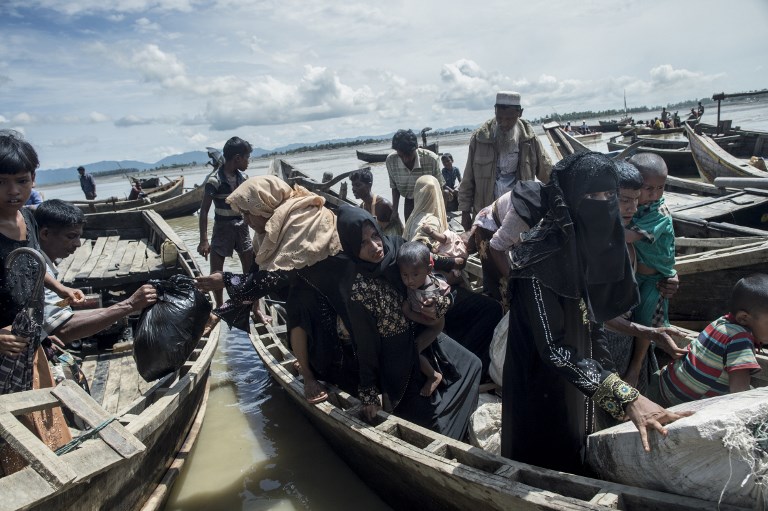 Rohingya Muslim refugees disembark from a boat in Teknaf to enter a camp for refugees after they crossed the border from Myanmar on October 3, 2017. / AFP PHOTO / FRED DUFOUR