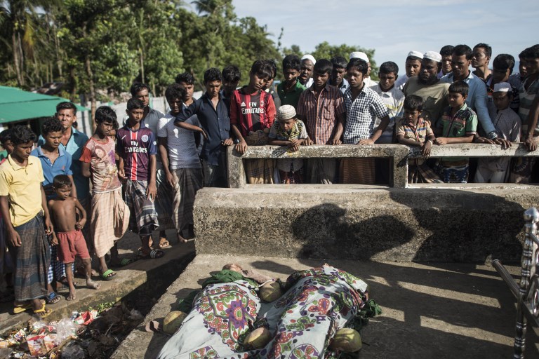 Bangladeshi people gather around the bodies of Rohingya Muslim refugees on Shah Porir Dwip Island near Teknaf on October 9, 2017, after a boat capsizing accident.
At least 12 Rohingya refugees, most of them children, drowned and scores more were missing Monday after their overloaded boat capsized in the latest tragedy to strike those fleeing violence in Myanmar. / AFP PHOTO / FRED DUFOUR