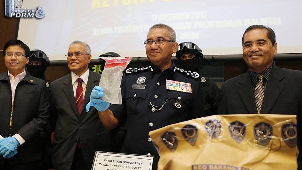 IGP Tan Sri Mohamad Fuzi Harun holding the spoils of the militant bust for the press | via PDRM Facebook