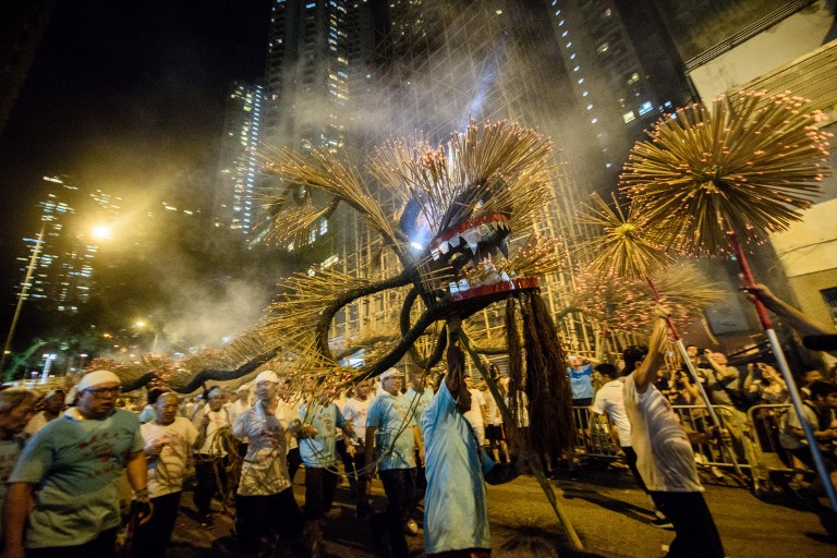 In this picture taken on October 3, 2017, participants take part in the annual Tai Hang “fire dragon” event, one of the highlights of the city’s mid-autumn festival, in Hong Kong. AFP PHOTO / Anthony Wallace
