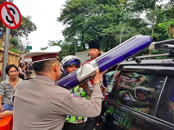 Jakarta Traffic Police officers confiscate a police light bar illegally installed on a civilian car on October 11, 2017. Photo: Instagram/@tmcpoldametro