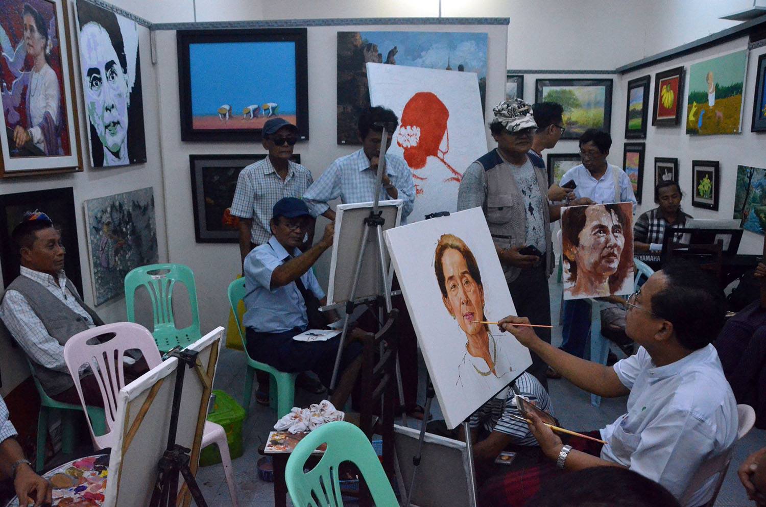Artists paint portraits of Aung San Suu Kyi on Sunday, October 8, 2017. Photo: MOI