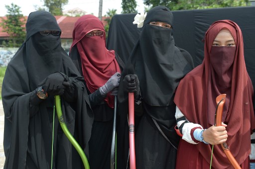 This picture, taken on November 12, 2017 shows members of Indonesia’s “Niqab Squad” posing for a photograph after participating in archery and horse riding lessons in Bekasi. Photo: AFP / ADEK BERRY 