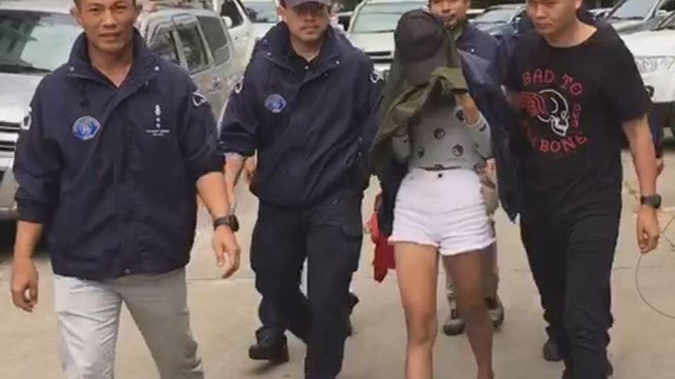 Suspect Panatda Suwanphithak, 21, being escorted by police. Photo: Ejan/Facebook