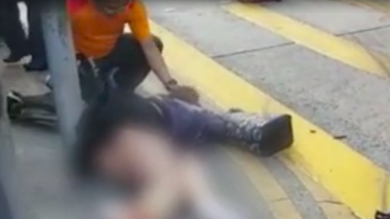 Screengrab via YouTube. A student from Guangzhou lies on the sidewalk after being hit by a double decker bus at a busy junction between Argyle Street and Nathan Road. Screengrab via YouTube.
