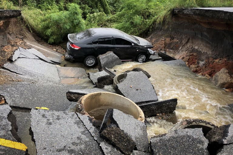 A car is stranded on a road that collapsed due to heavy flooding in the southern Thai district of Songkhla on Nov. 30, 2017. Photo: Tuwaedaniya Meringing/ AFP