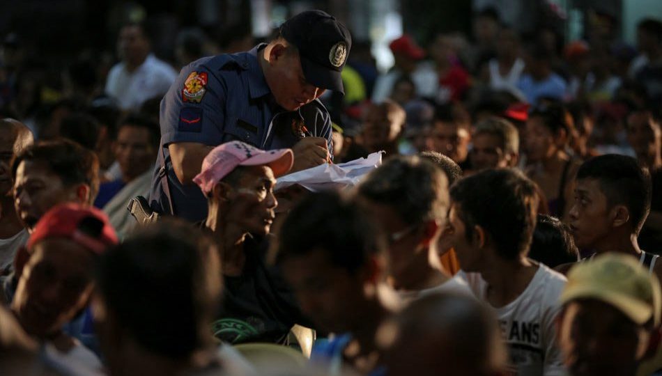 A police officer lists down names of suspected drug users and pushers at a processing center in Tondo, Manila on July 13, 2016. PHOTO: Jonathan Cellona, ABS-CBN News