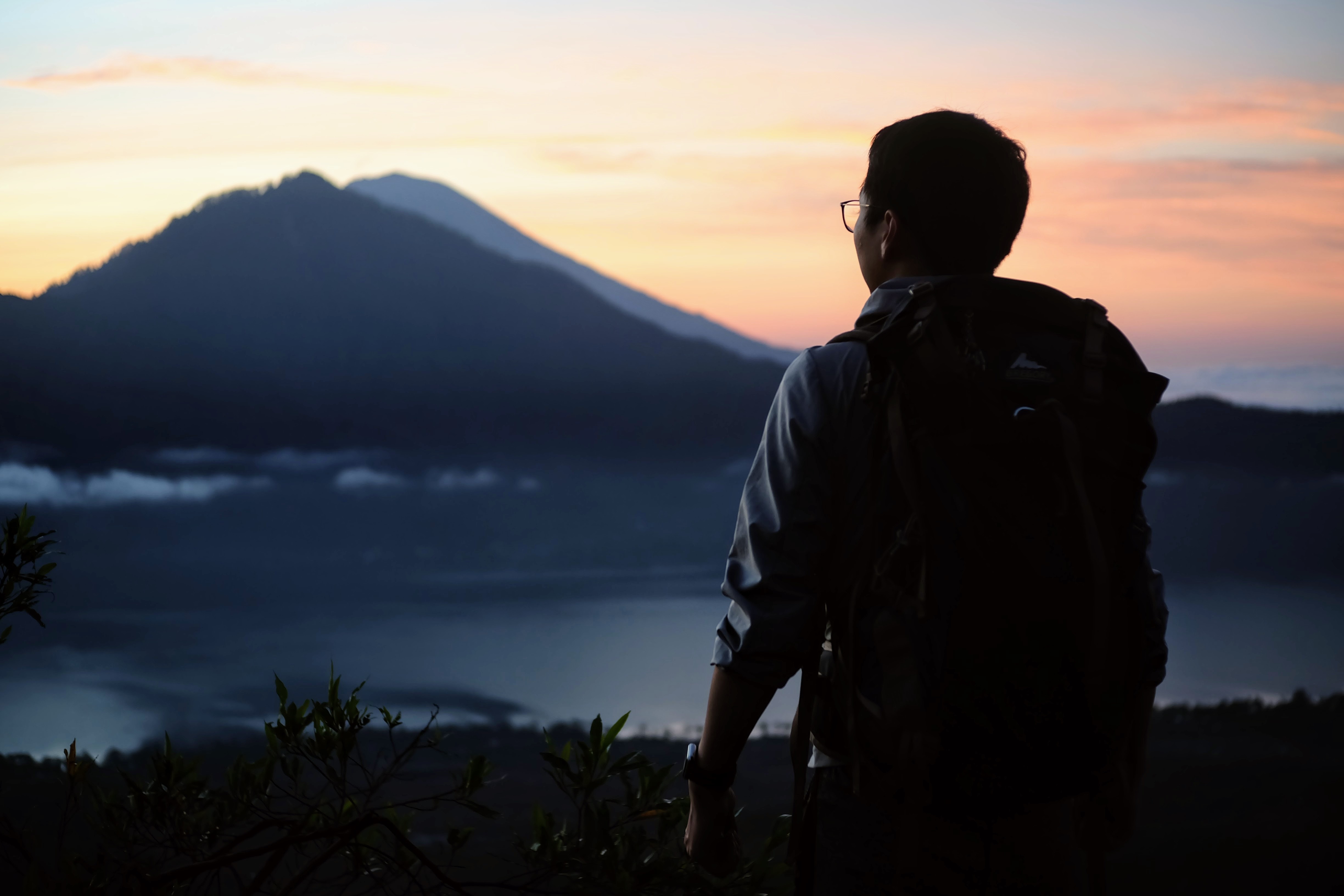 A hiker looks out over Mount Agung. Photo: Wang Dongxu/Unsplash