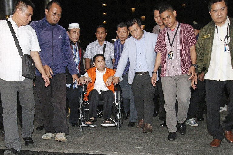 This picture taken on November 19, 2017 shows Parliament speaker Setya Novanto (in orange) being escorted by officials from the Corruption Eradication Commission (KPK) in Jakarta. / AFP PHOTO / RAHMAT KASUBA