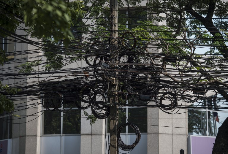 This photo taken on Jan. 3, 2018 shows a knot of cables hanging over Wireless Road in Bangkok. Photo: Lillian Suwanrumpha/ AFP