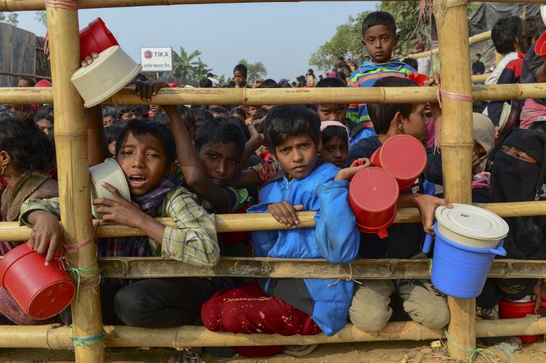 Rohingya Muslim refugees wait for food aid at Thankhali refugee camp in Bangladesh’s Ukhia district on January 12, 2018. / AFP PHOTO / Munir UZ ZAMAN