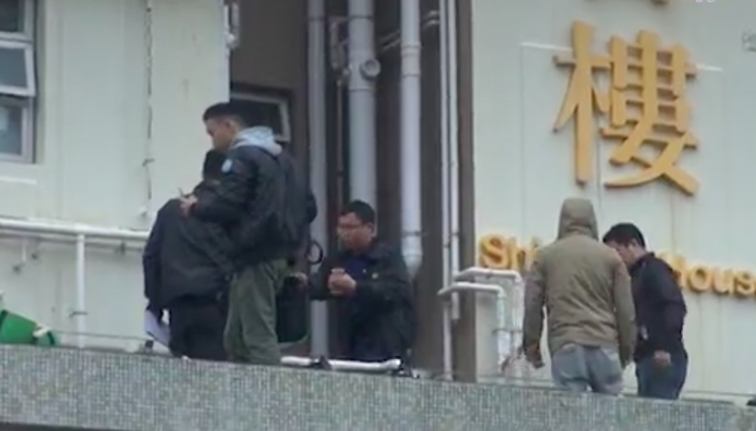 Police officers at the scene outside a Tseung Kwan O housing estate where a woman was arrested on suspicion of throwing her dog out of a window. Screengrab via Apple Daily video.