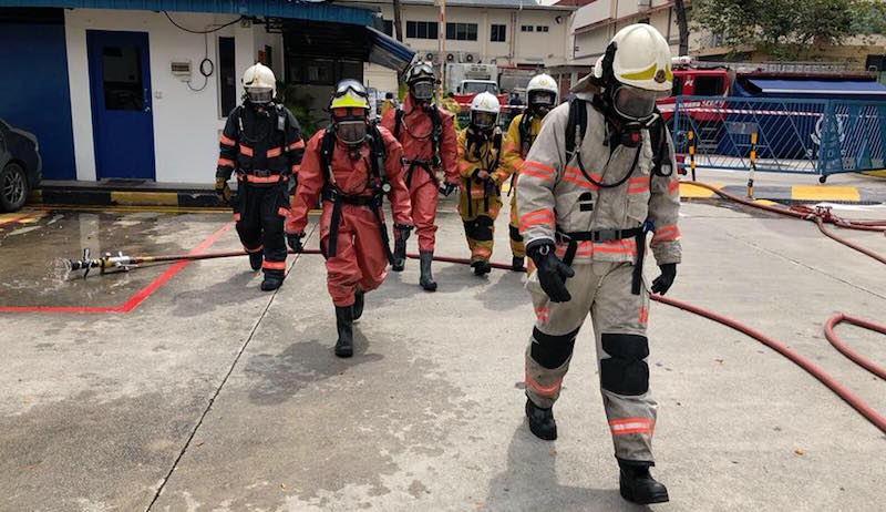 HazMat Specialists in protective suits going into the building. Photo: Singapore Civil Defence Force/Facebook