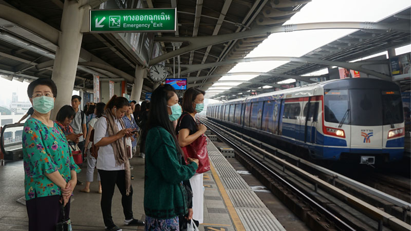 Bangkokians wearing face masks wait for a train at Mo Chit BTS station, Feb. 9, 2018. Photo: Prae Sakaowan/ Coconuts Media