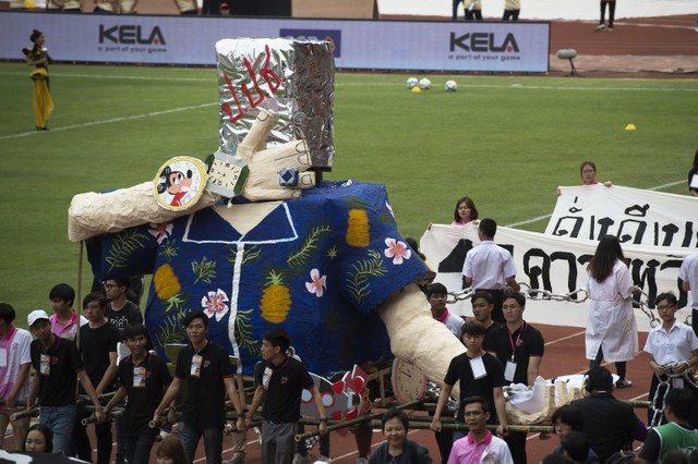 University students carry a parade float mocking Thailand’s junta number two Prawit Wongsuwan over a current scandal over his undeclared collection of luxury watches, during the annual football match between Thammasat University and Chulalongkorn University in Bangkok on February 3, 2018.
Thai students with huge banners and caricature puppets on February 3 delivered the latest satirical swipe at the junta’s number two — known as the “Rolex General” for his collection of undeclared luxury watches. / AFP PHOTO / LILLIAN SUWANRUMPHA