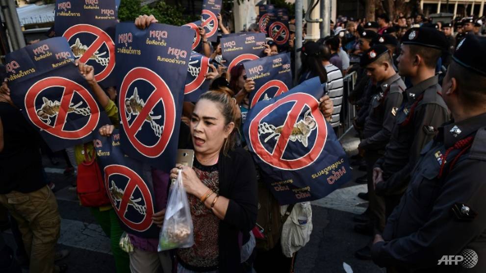 Protesters march past a police cordon whilst holding posters mocking Thai Prime Minister Prayuth Chan-O-Cha as they gather to demand elections in Bangkok on February 10, 2018. Scores of Thais on February 11 gathered in defiance of a junta ban on protests to call for a return to democracy, as public anger mounts over prolonged military repression.
LILLIAN SUWANRUMPHA / AFP