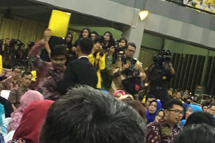 A Universitas Indonesia student being ushered out by the president’s security detail for holding up a yellow card for President Jokowi on February 2, 2018. Photo: Video screengrab