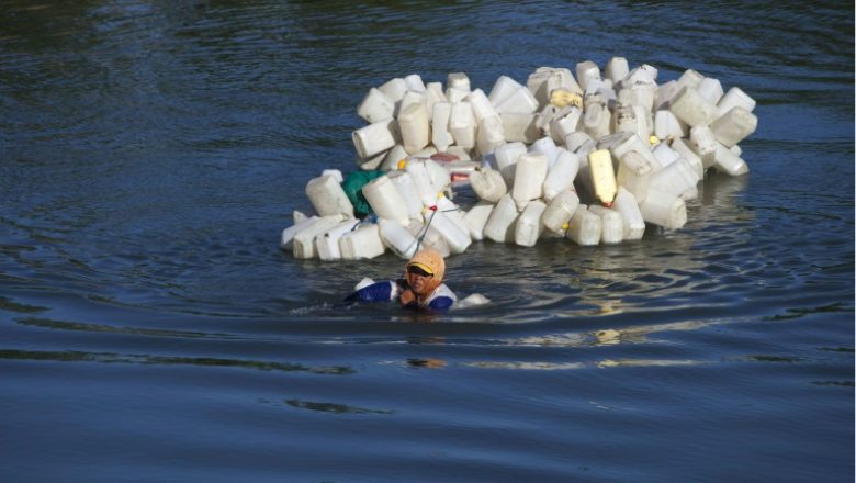This photo taken on March 22, 2018 shows Indonesian Hasria swimming with hundreds of jars tied to her back to get clean water in Tinambung, West Sulawesi. Indonesian villager Mama Hasria swims upstream with about 200 empty jerry cans tied to her back, a daily trip she and other local women make to get clean water for their community on Sulawesi island. As a scorching sun beats down, the 46-year-old Hasria makes the four kilometre (2.5 mile), hour-long trip along the murky 
YUSUF WAHIL / AFP