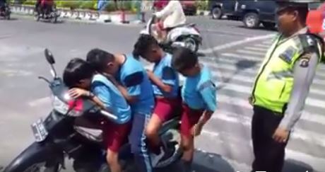 A police officer in Pematangsiantar, North Sumatra, stopping 4 kids who were riding a motorcycle. Photo: Facebook