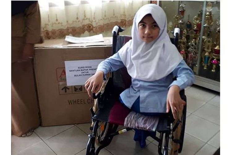 A 10-year-old Indonesian girl who was born without legs receiving a wheelchair from President Joko Widodo. Photo: Instagram via Kompas