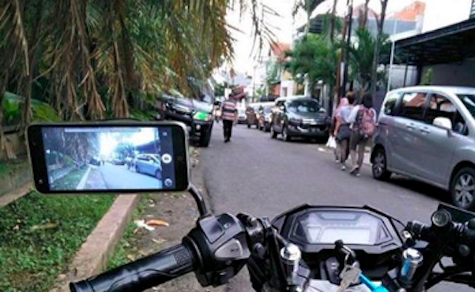 A mobile phone being used as a side view mirror in Indonesia. Photo: Instagram/@newdramaojol.id