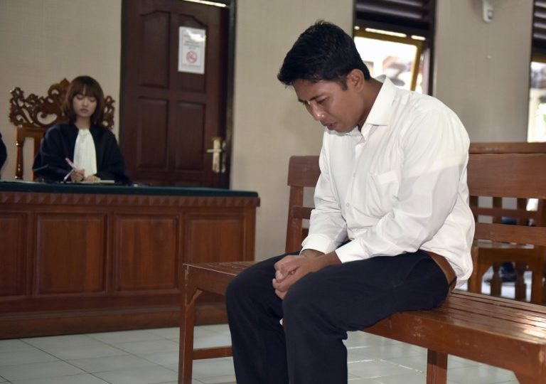 Indonesian defendant I Putu Astawa, 25, sits in a court in Denpasar on March 26, 2018, as he is sentenced to 15 years in jail for stabbing an elderly Japanese couple to death during a botched burglary. 
AFP PHOTO / Raka Yoda