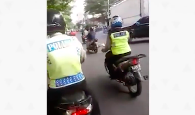 Two traffic cops in Jakarta drive away after one of them calls a motorist a “dog” for not being able to give him enough bribery money. Photo: Video screengrab from Facebook