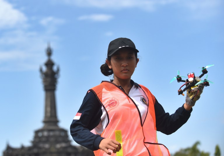 A woman holds a race drone during the FAI Drone Racing World Cup event in Denpasar on Indonesia’s resort island of Bali on April 7, 2018. Photo: Sonny Tumbelaka/AFP