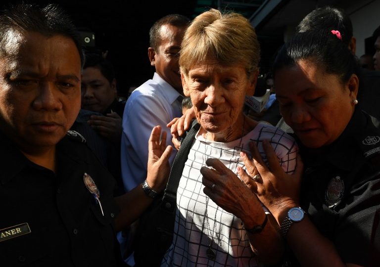 This photo taken on April 17, 2018 shows Australian catholic nun Sister Patricia Fox (C) being escorted by immigration officers while leaving a detention facility after her release at the Immigration headquarters in Manila, a day after she was arrested.
The Philippines on April 25 ordered the deportation of an elderly Australian nun who angered President Rodrigo Duterte, accusing her of engaging in illegal political activities outside of her missionary work. (Photo: Ted Aljibe/AFP Photo)