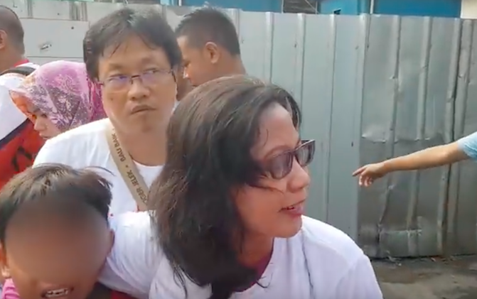 A woman protecting a little boy, presumably her son, who cried after being intimidated by an anti-Jokowi crowd during a political rally in Jakarta on April 29, 2018. Photo: Youtube/Jakartanicus