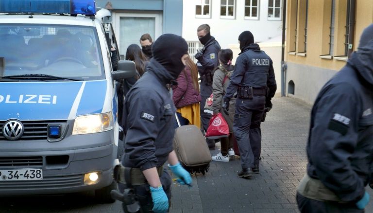 Federal police officers take into custody women after a raid in a red light district of Siegen, western Germany. Photo: AFP