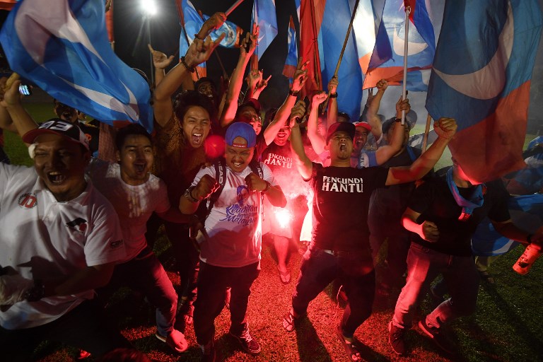 Supporters of former Malaysian prime minister and opposition candidate Mahathir Mohamad celebrate in Kuala Lumpur on early May 10, 2018.
Malaysia’s opposition alliance headed by veteran ex-leader Mahathir Mohamad, 92, has won a historic election victory, official results showed on May 10, ending the six-decade rule of the Barisan Nasional (BN) coalition.  / AFP PHOTO / Mohd RASFAN