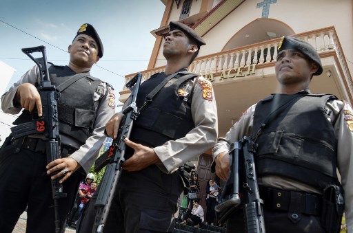 Police stand guard outside a church in Banda Aceh on May 13, 2018 following attacks on churches in Surabaya, East Java. 
A wave of blasts, including a suicide bombing, struck churches in Indonesia on May 13, killing at least nine and wounding dozens of others in the deadliest attack in years to strike the world’s biggest Muslim-majority country. / AFP PHOTO / CHAIDEER MAHYUDDIN