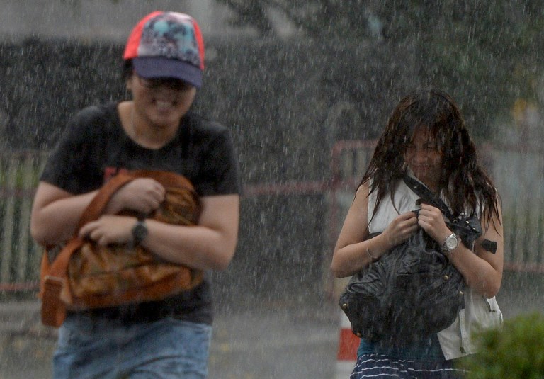 Tourists walk through heavy rain in Bangkok on April 11, 2013. File photo: AFP