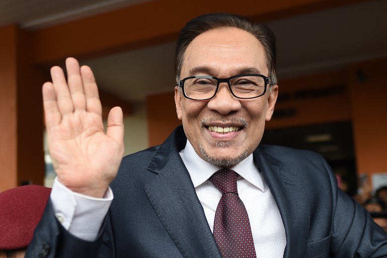 Jailed former opposition leader and current federal opposition leader Anwar Ibrahim greets supporters after his release from the Cheras Hospital Rehabilitation in Kuala Lumpur on May 16, 2018.
The release of Anwar from prison marks yet another sharp turn in a roller-coaster political life that has left a profound mark on Malaysian politics and society. Anwar was pardoned and released on May 16 after serving three years for a sodomy conviction widely considered a railroad job and now quashed following the stunning defeat of a Malaysian regime that had ruled for six decades.
 / AFP PHOTO / MOHD RASFAN
