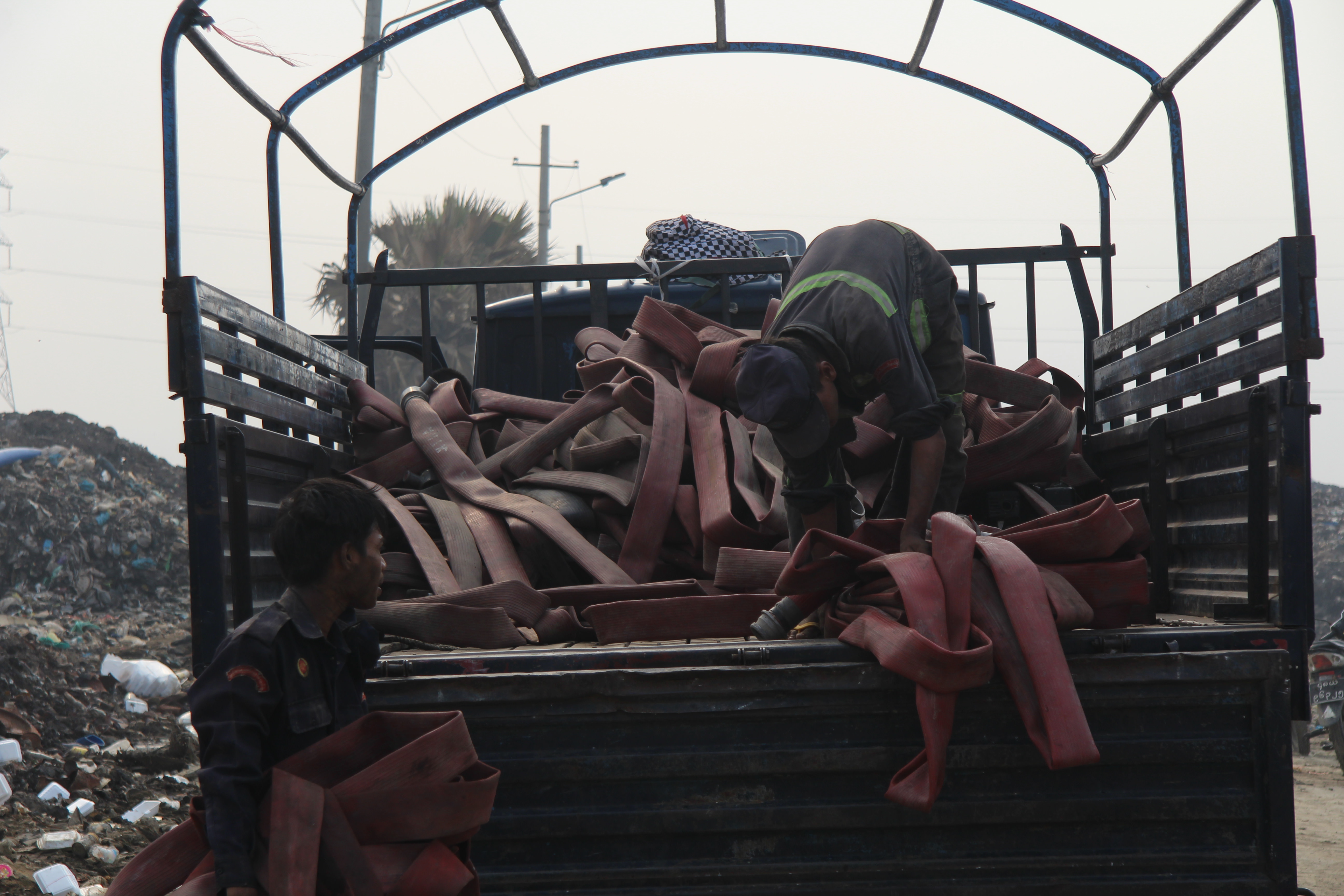 Firefighters in the Htein Bin landfill pack up their hoses