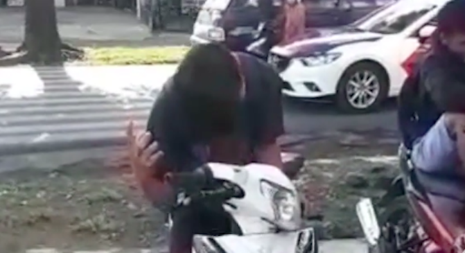 A motorcyclist in Indonesia pretending to be possessed by a ghost to avoid a ticket. Photo: Video screengrab
