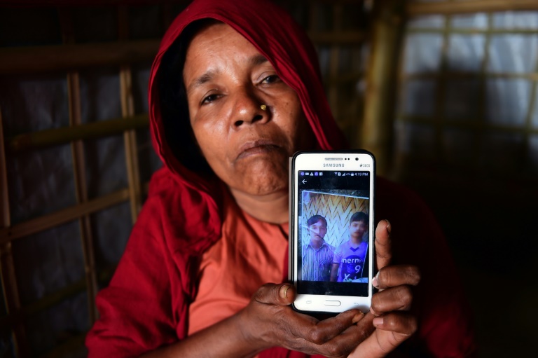 Rohingya refugee Khadija Begum, the mother of 16-year-old Robi Alam, shares a photograph of two of her other sons. AFP / MUNIR UZ ZAMAN