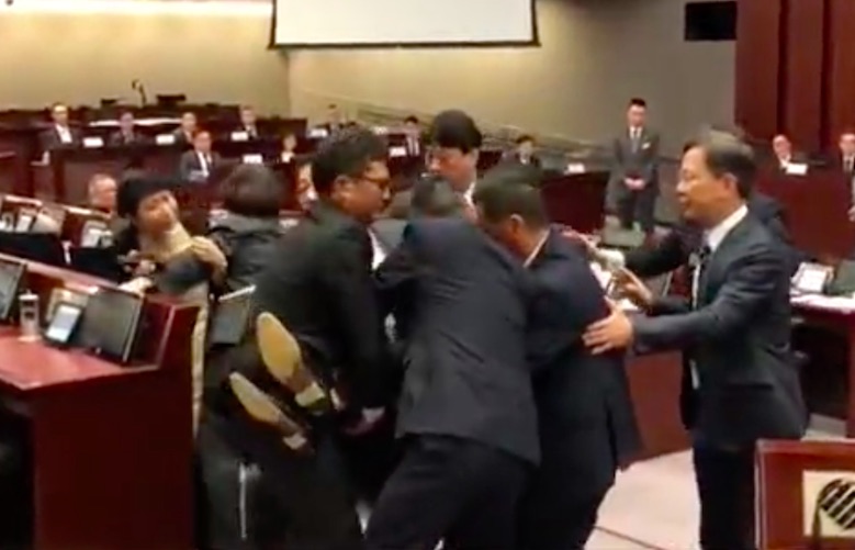 Pro-democracy lawmaker Au Nok-hin being carried out of a legislative council committee meeting. Screengrab via Apple Daily.