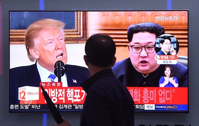 A man walks past a television news screen showing North Korean leader Kim Jong Un and US President Donald Trump at a railway station in Seoul on May 16, 2018. Photo: Jung Yeon-je / AFP