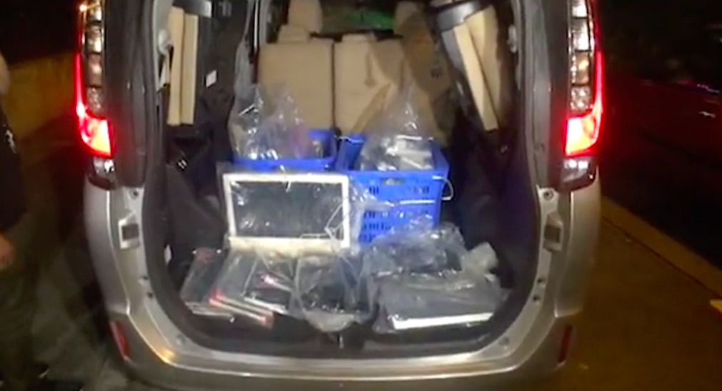 Police fill up their van with evidence of the Mid-Levels vice operation. Screengrab via Apple Daily.