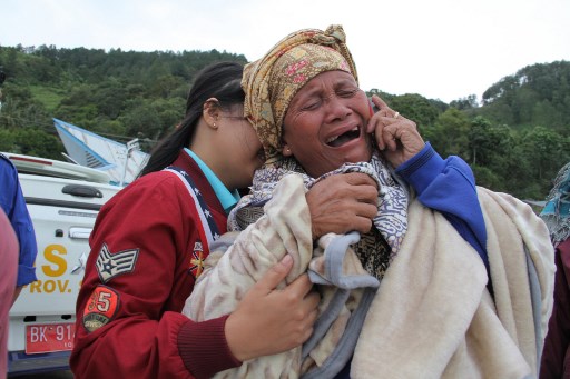 A woman cries as she finds out her family are listed as missing, at the Lake Toba ferry port in the province of North Sumatra on June 19, 2018, after a boat capsized the day before. AFP PHOTO / Lazuardy Fahmi