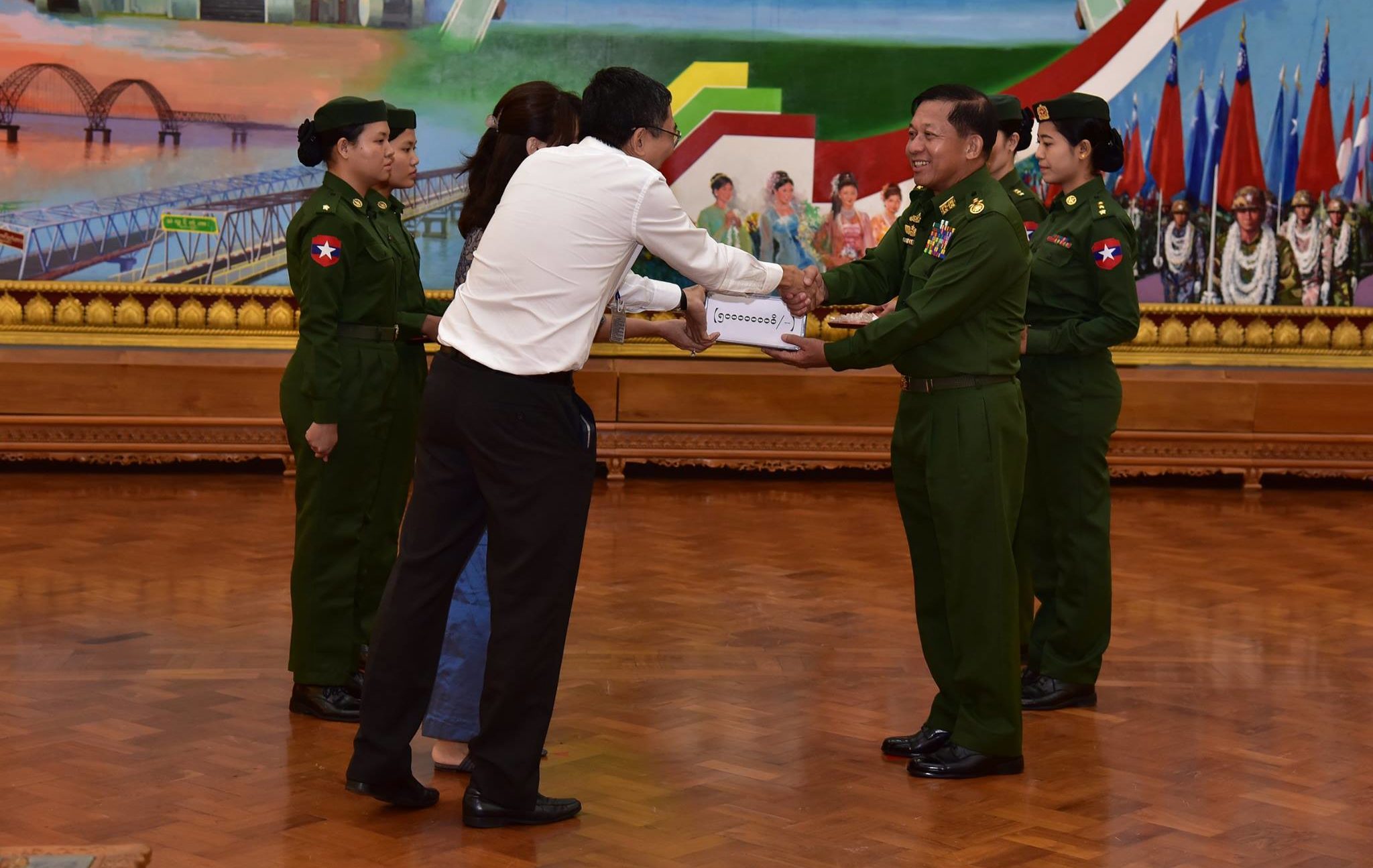 A donor hands cash to Senior General Min Aung Hlaing at a ceremony in Naypyidaw on Sept. 1, 2017. Photo: Facebook / Senior General Min Aung Hlaing